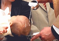 Bambino battezzato con acqua dal sacerdote